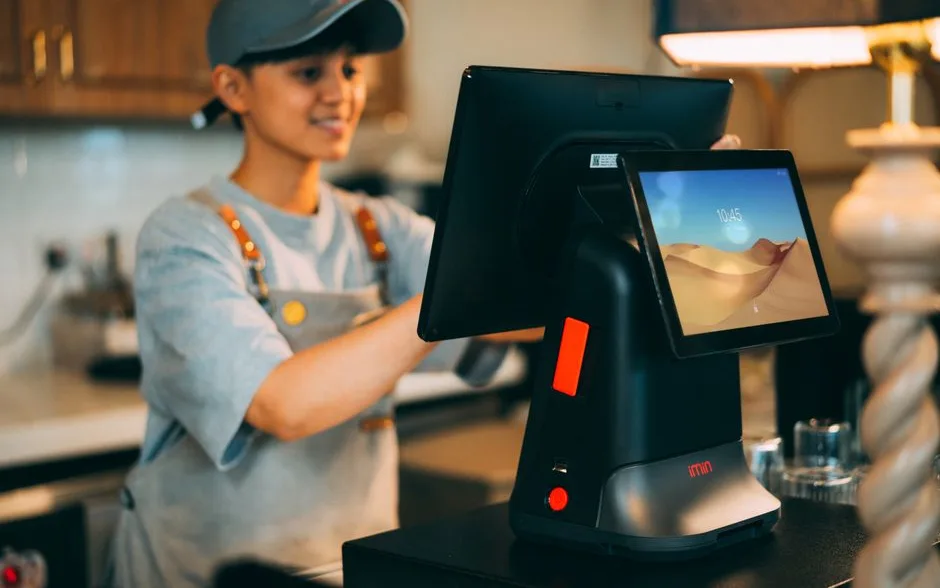 Commerçante qui enregistre une vente sur son terminal de caisse